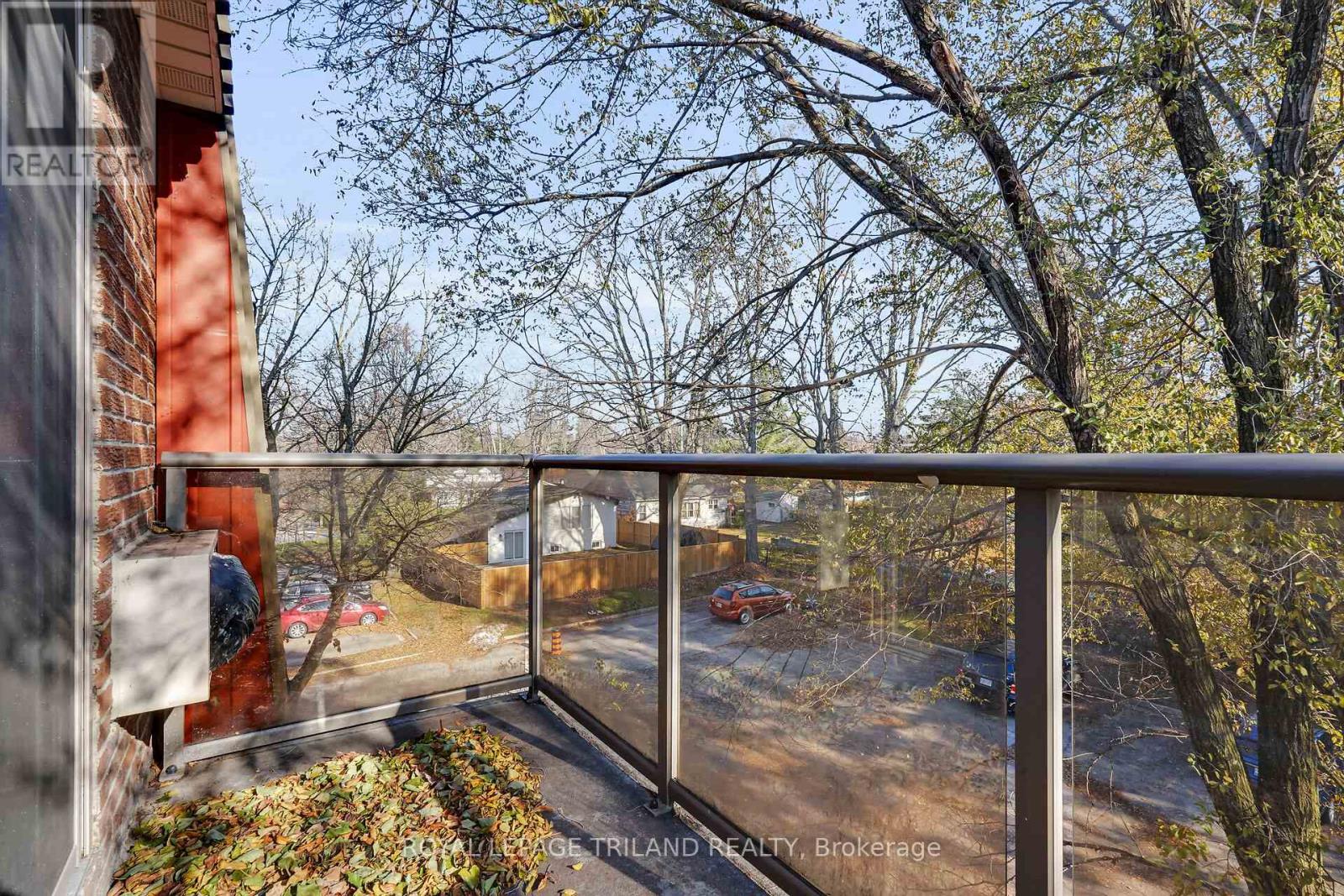 A balcony view of a residential area with cars and trees.