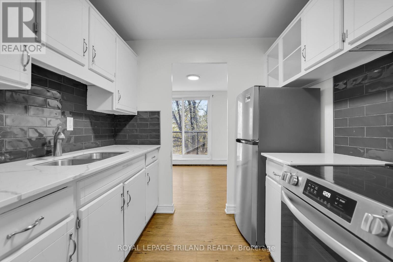 A modern kitchen with white cabinets and stainless steel appliances.