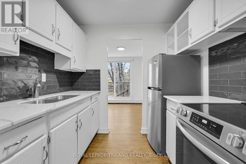 A modern kitchen with white cabinets and stainless steel appliances.