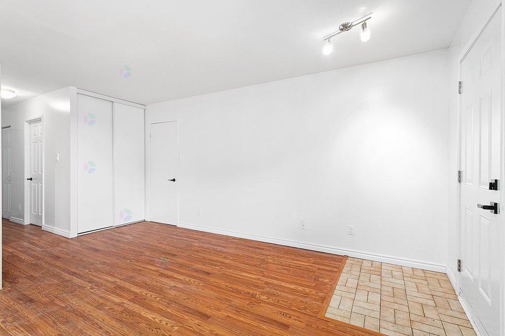 A room with wooden flooring and white walls.