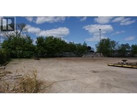 A large, empty parking lot with a sign for Royal LePage Macro Realty in Brockville.