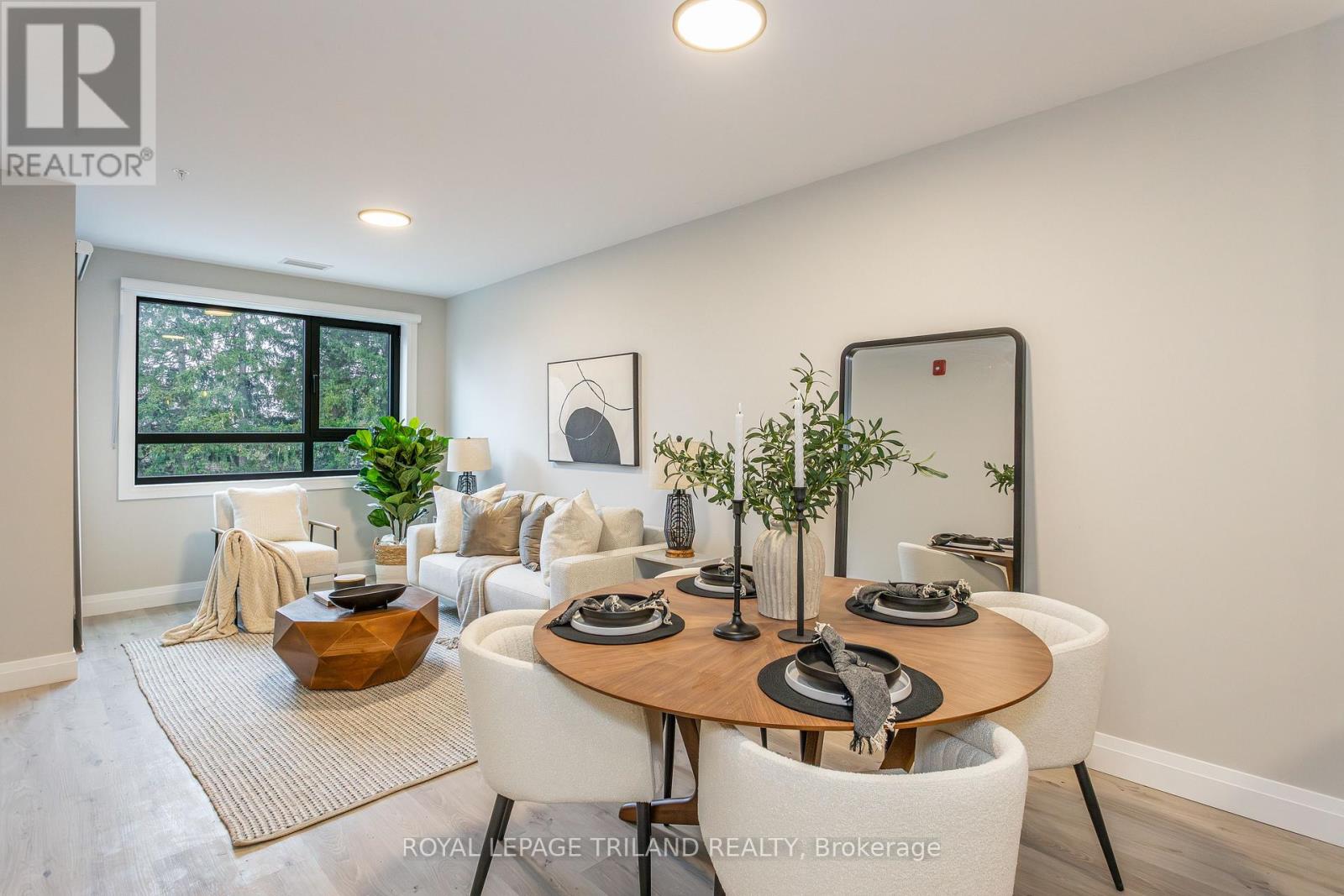 A well-lit dining room with a round table set for six.