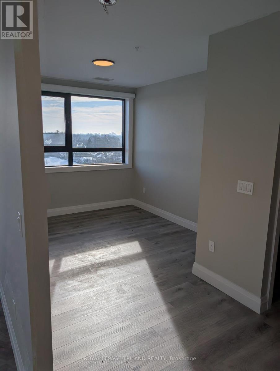 A room with a window and wooden flooring.