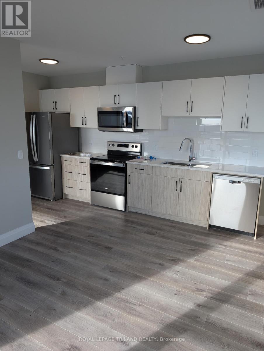 A kitchen with white cabinets and a wooden floor.