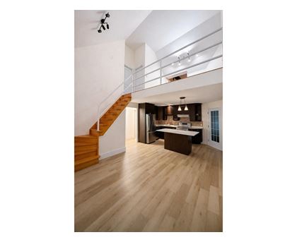 A modern interior with a staircase and a kitchen area.