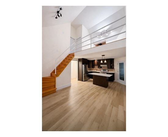 A modern interior with a staircase and a kitchen area.