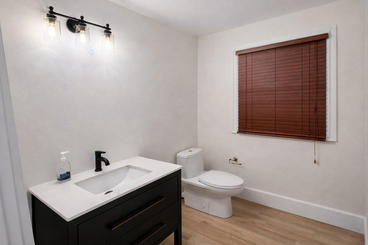 A bathroom with a white sink and a toilet.
