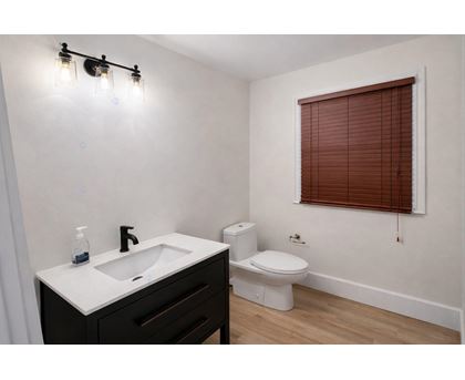 A bathroom with a white sink and a toilet.