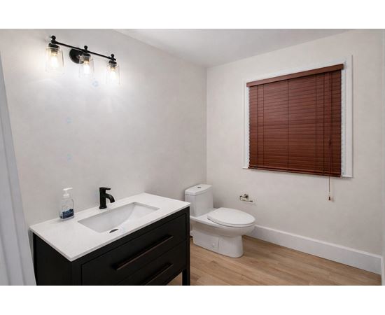 A bathroom with a white sink and a toilet.