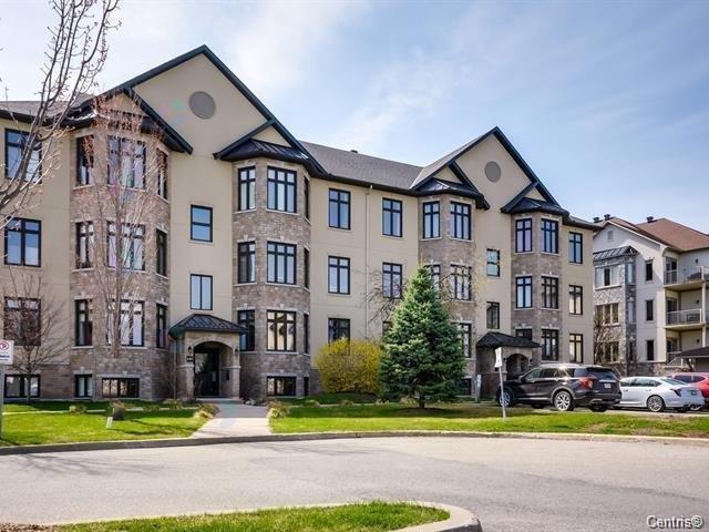 A large, multi-story residential building with a mix of stone and siding exterior.