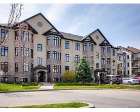 A large, multi-story residential building with a mix of stone and siding exterior.