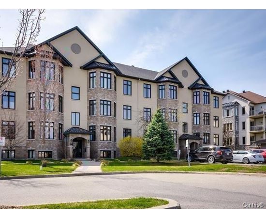 A large, multi-story residential building with a mix of stone and siding exterior.