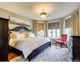 A bedroom with a large bed and a red chair.