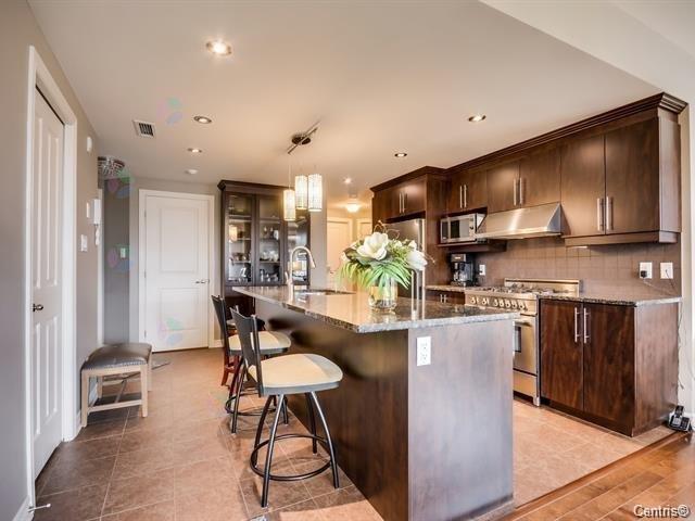 A kitchen with brown cabinets and a large island.
