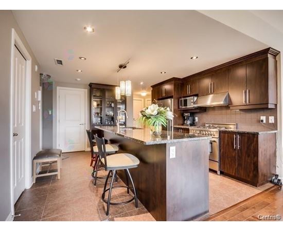 A kitchen with brown cabinets and a large island.