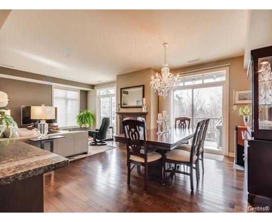 A dining room with a wooden table and chairs.