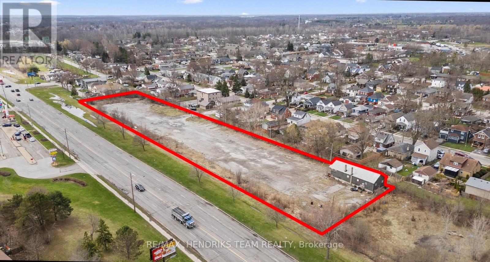 An aerial view of a residential area with a red outlined property for sale.