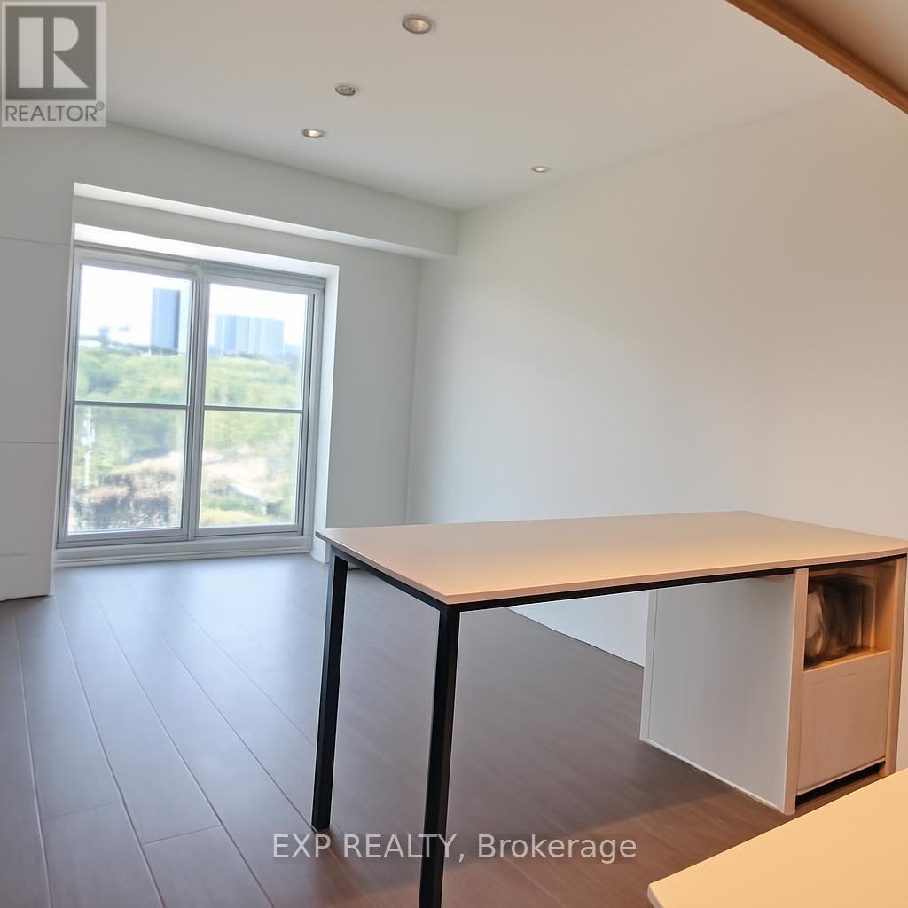 A white table with a black frame is in a room with a sliding glass door.