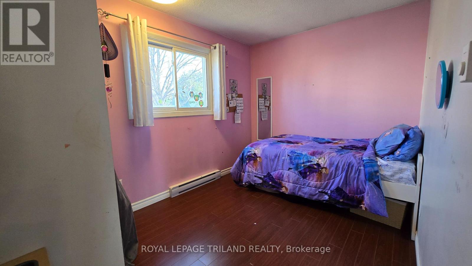 A bedroom with a bed and a window.