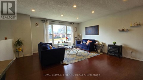 A living room with a dark blue couch and a television on the wall.