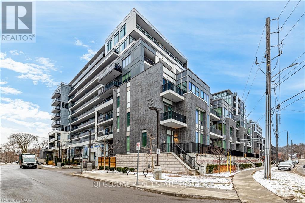 A modern multi-story building with a glass facade and a truck parked in front.