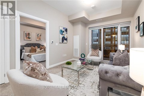 A living room with a grey couch and a glass coffee table.