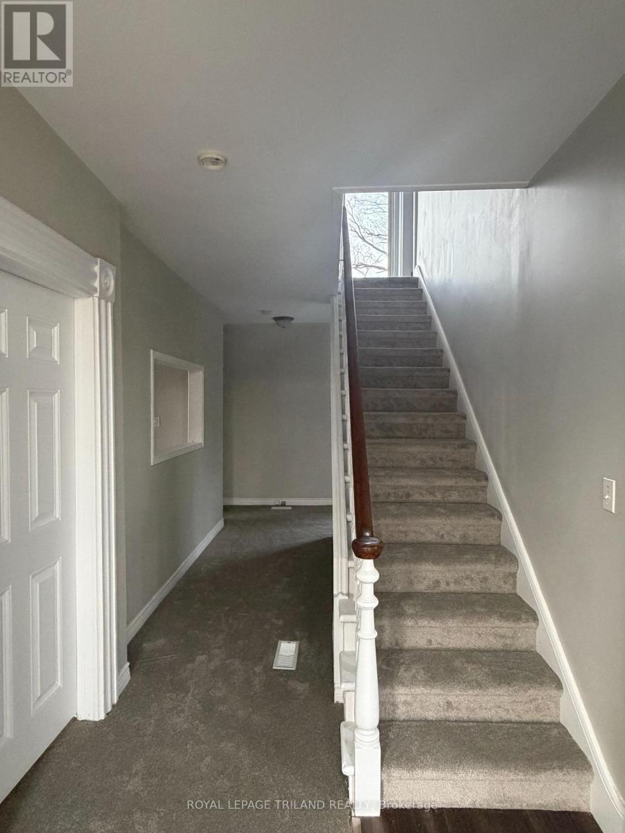 A staircase with a carpeted runner and wooden balusters.