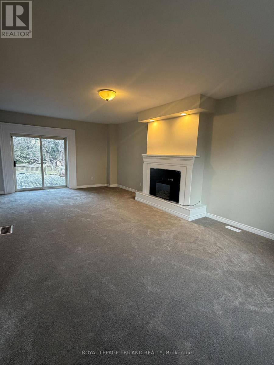 A spacious living room with a fireplace and large windows.