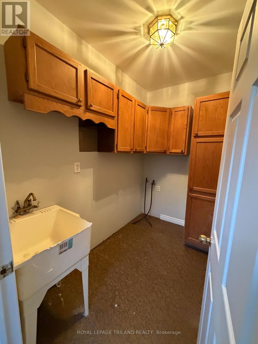 A kitchen with wooden cabinets and a white sink.