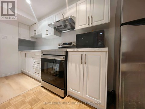 A modern kitchen with white cabinets and stainless steel appliances.