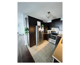 A kitchen with a refrigerator, microwave, and oven.
