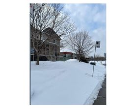 A snow-covered ground with a building in the background.