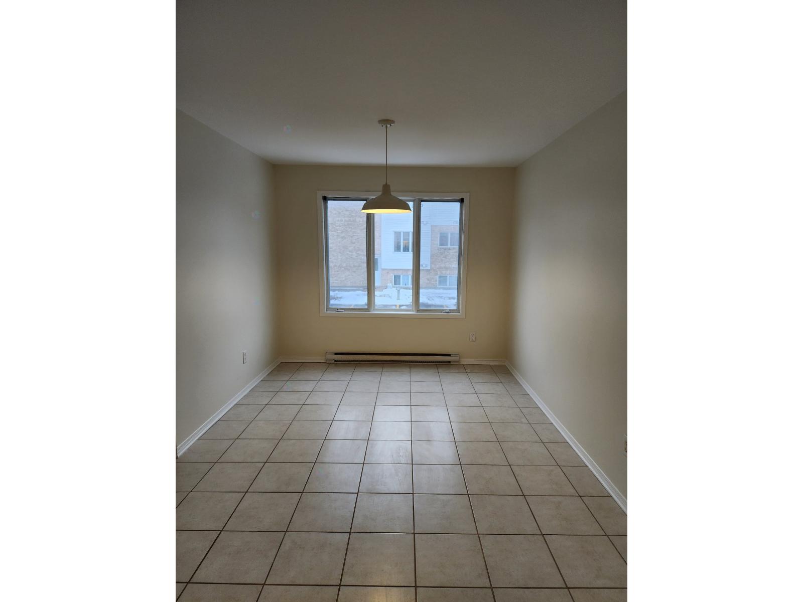 Empty room with a window and tiled floor.