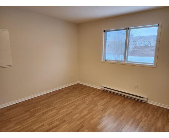 A room with a window and a radiator on the floor.