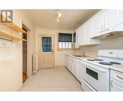 A kitchen with white appliances and cabinets.