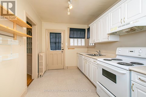 A kitchen with white appliances and cabinets.