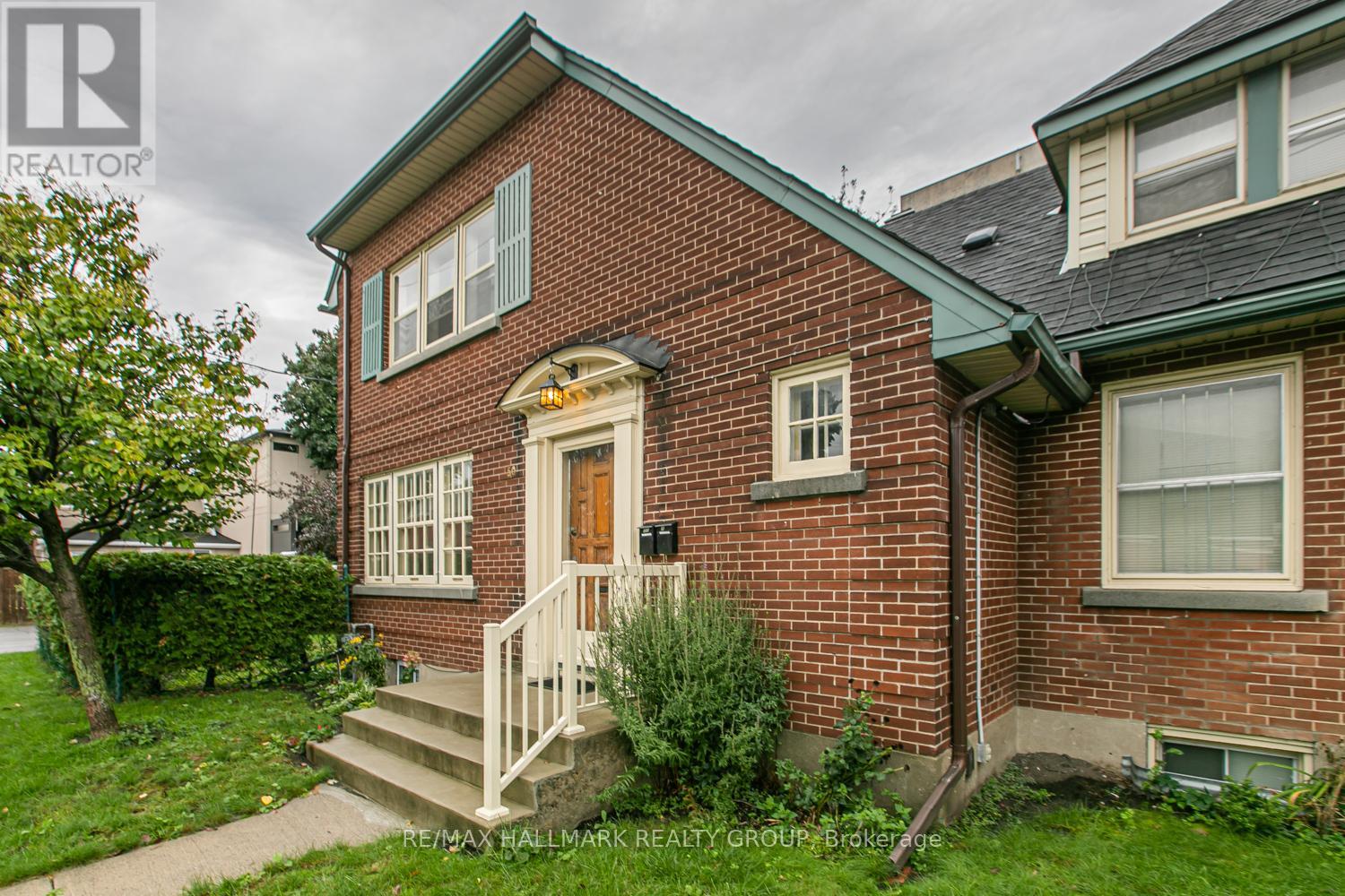 A red brick house with a white door and windows.