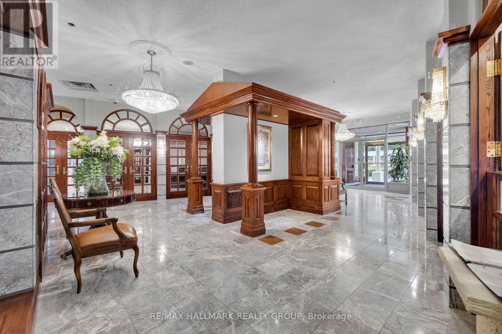 A spacious foyer with marble floors and wooden furniture.
