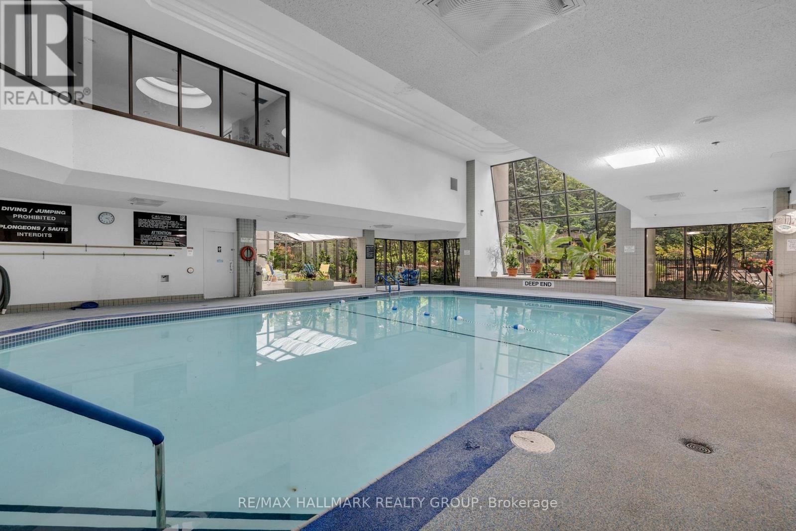 A large indoor swimming pool with a blue edge and a white interior.
