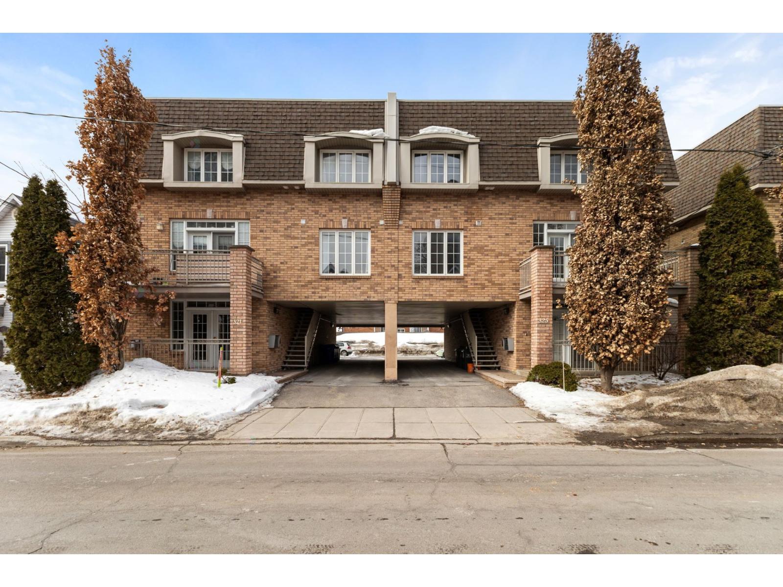 A large brick building with a garage door open.