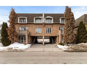 A large brick building with a garage door open.