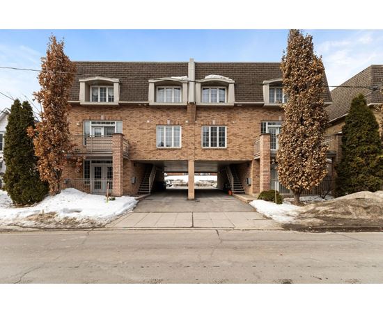 A large brick building with a garage door open.