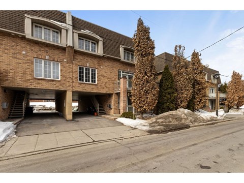 A large brick building with a garage underneath it.