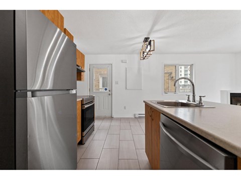 A kitchen with a stainless steel refrigerator and a sink.