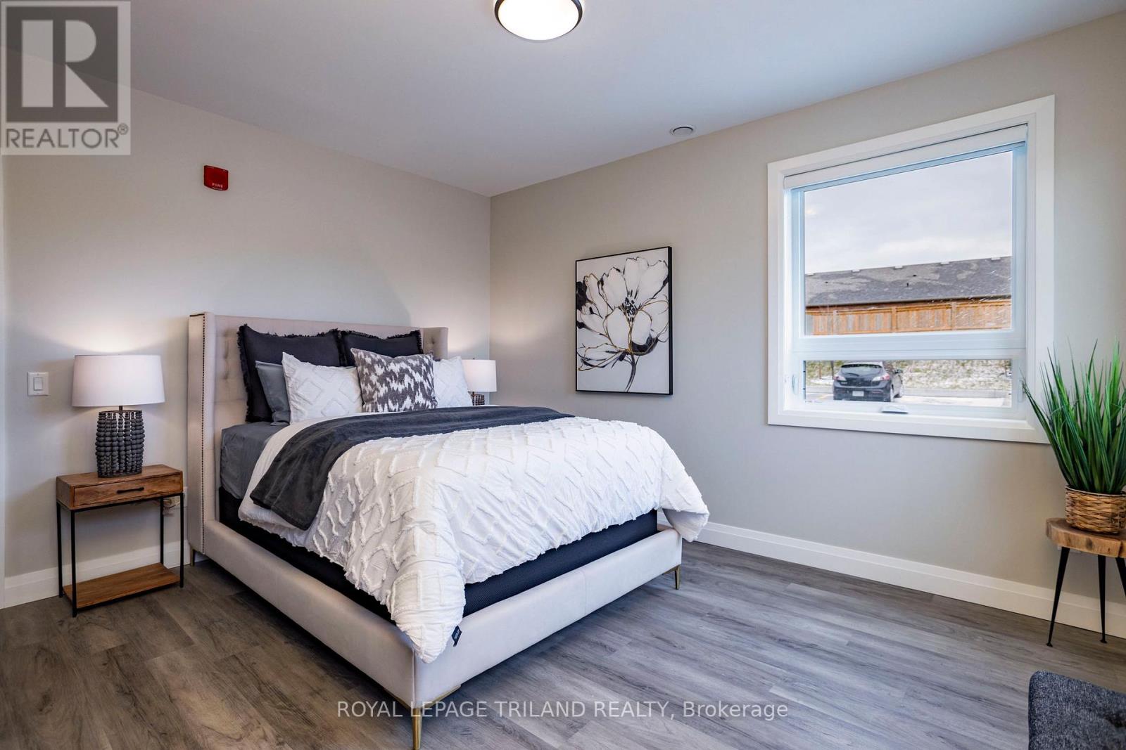 A bedroom with a large bed and a window overlooking a street.