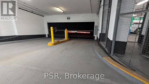 A parking garage with a yellow pole and a sign that says "PSR Brokerage".