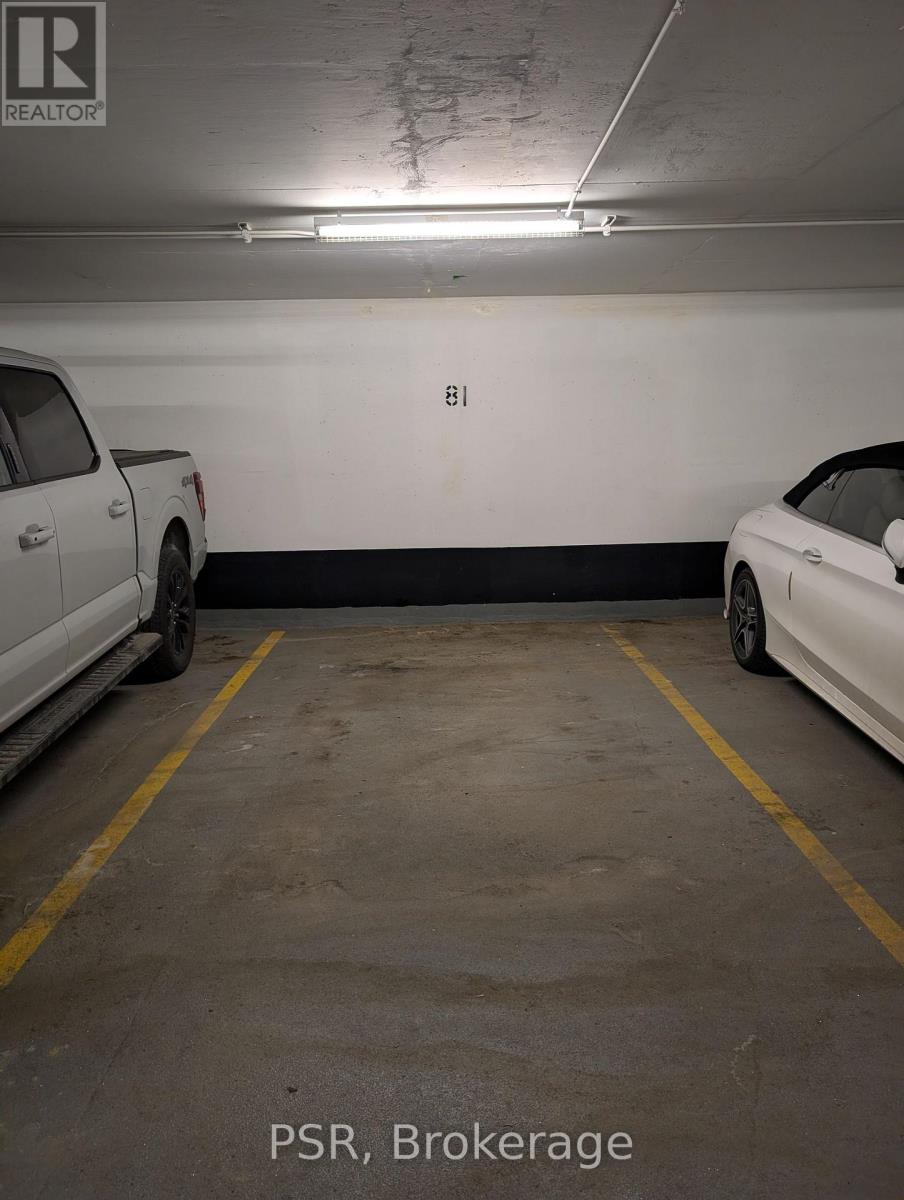 A parking garage with a white car parked on the left and a white car parked on the right.