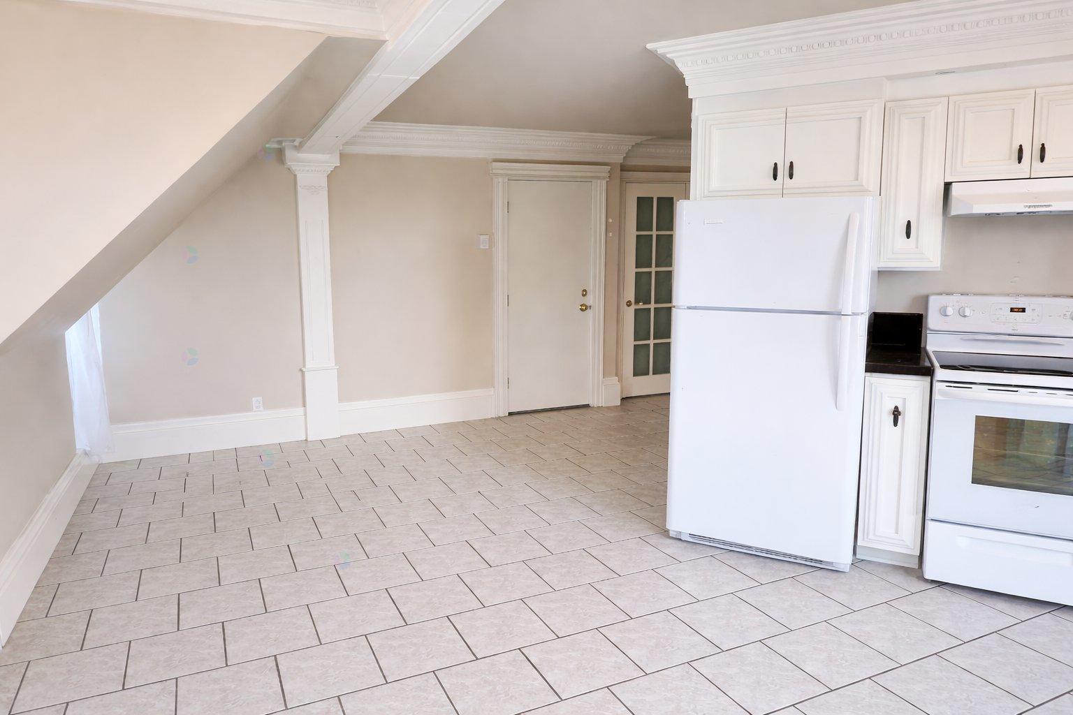A kitchen with white appliances and cabinets.