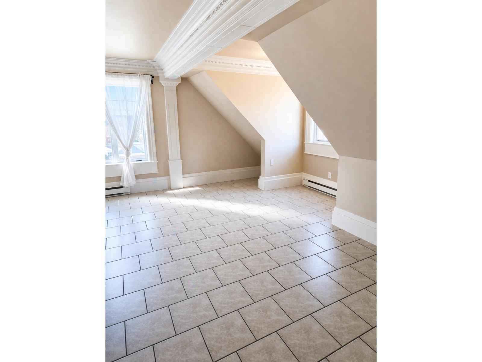 A room with a tiled floor and a window with curtains.
