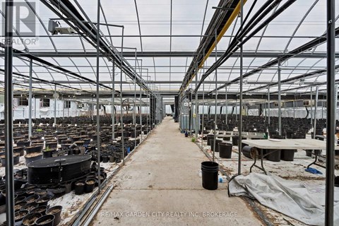 A greenhouse with plants growing in it and a sign that says RE/MAX Garden City Realty, Inc. Brokerage.